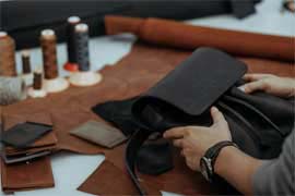 How to Select Leatherworking Tools That Last Generations; The master makes a leather bag. A close up, a product from skin in hands. Handwork