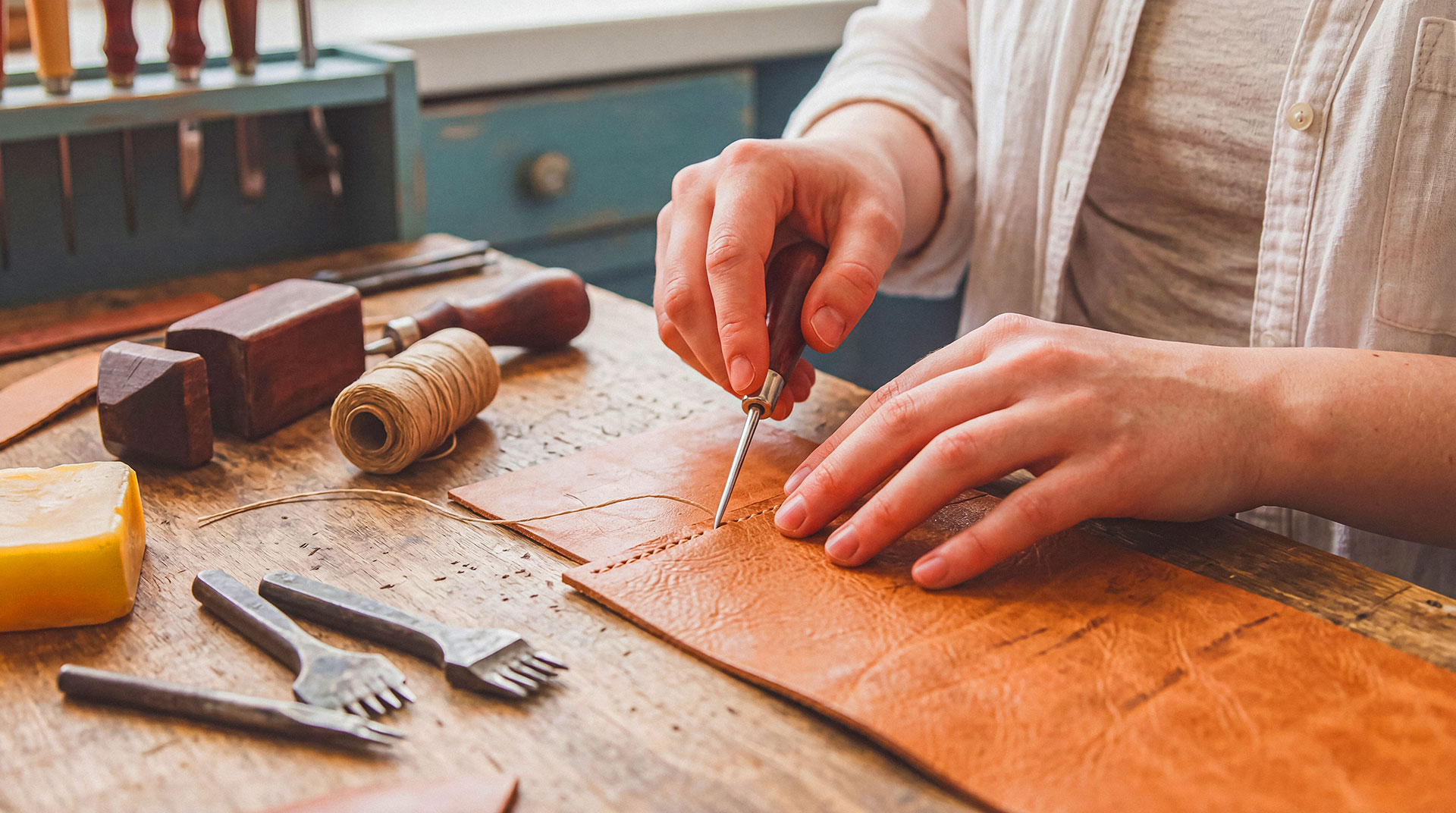 Crafting hands stitching leather using needle and thread