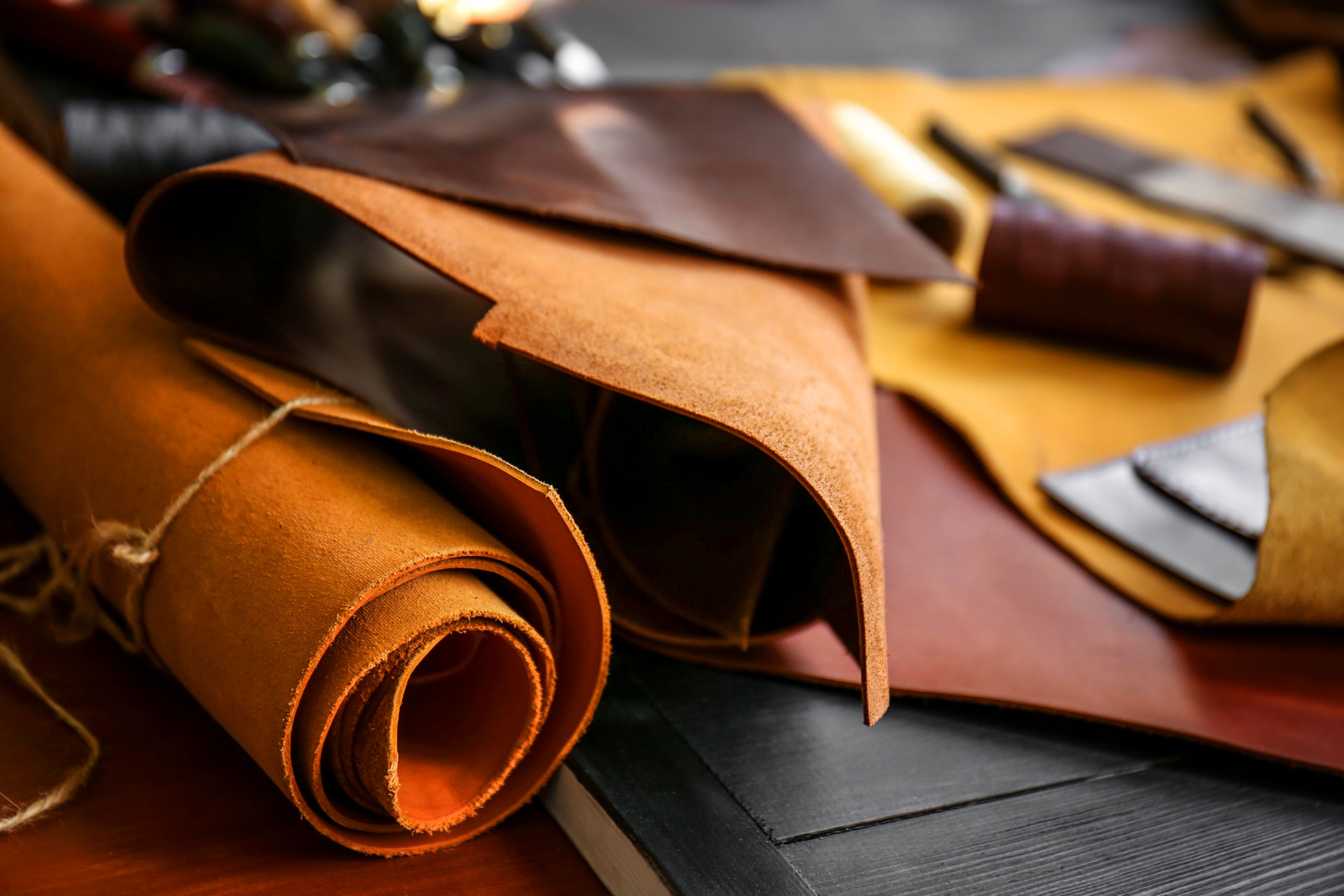 Rolled leather hides in various colors on workshop table